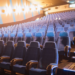 Sala de cinema com poltronas vermelhas e tela grande - filmes mais esperados de junho 2026