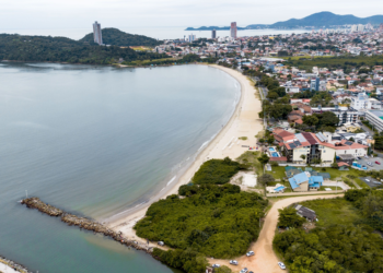 Praia tropical brasileira com águas cristalinas e vegetação exuberante