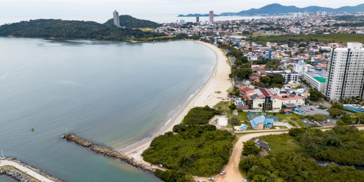Praia tropical brasileira com águas cristalinas e vegetação exuberante