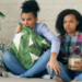 Duas mulheres assistindo séries na televisão com pipoca